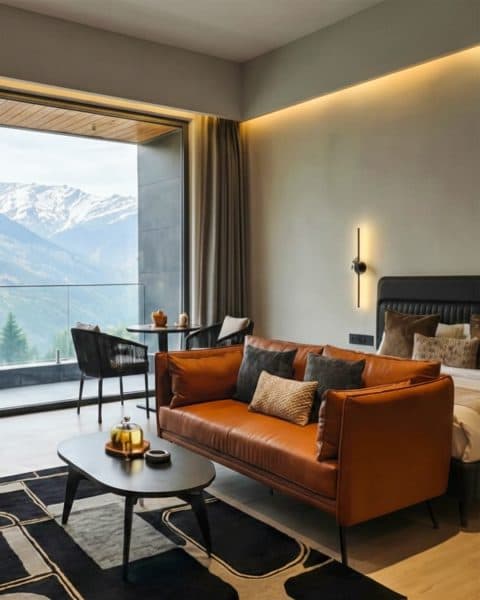 EKAM suite living area opening onto a private balcony with a Himalayan mountain view