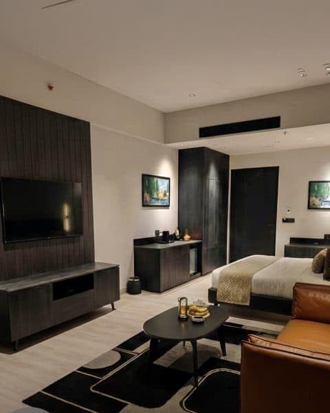 EKAM suite lounge area with wood-panelled media wall
