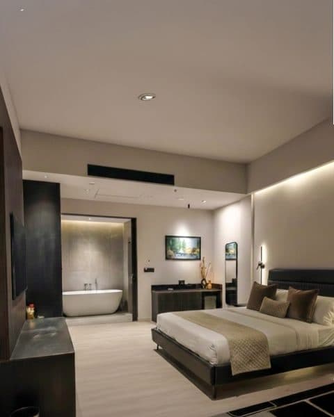 EKAM suite bedroom opening into a freestanding soaking tub