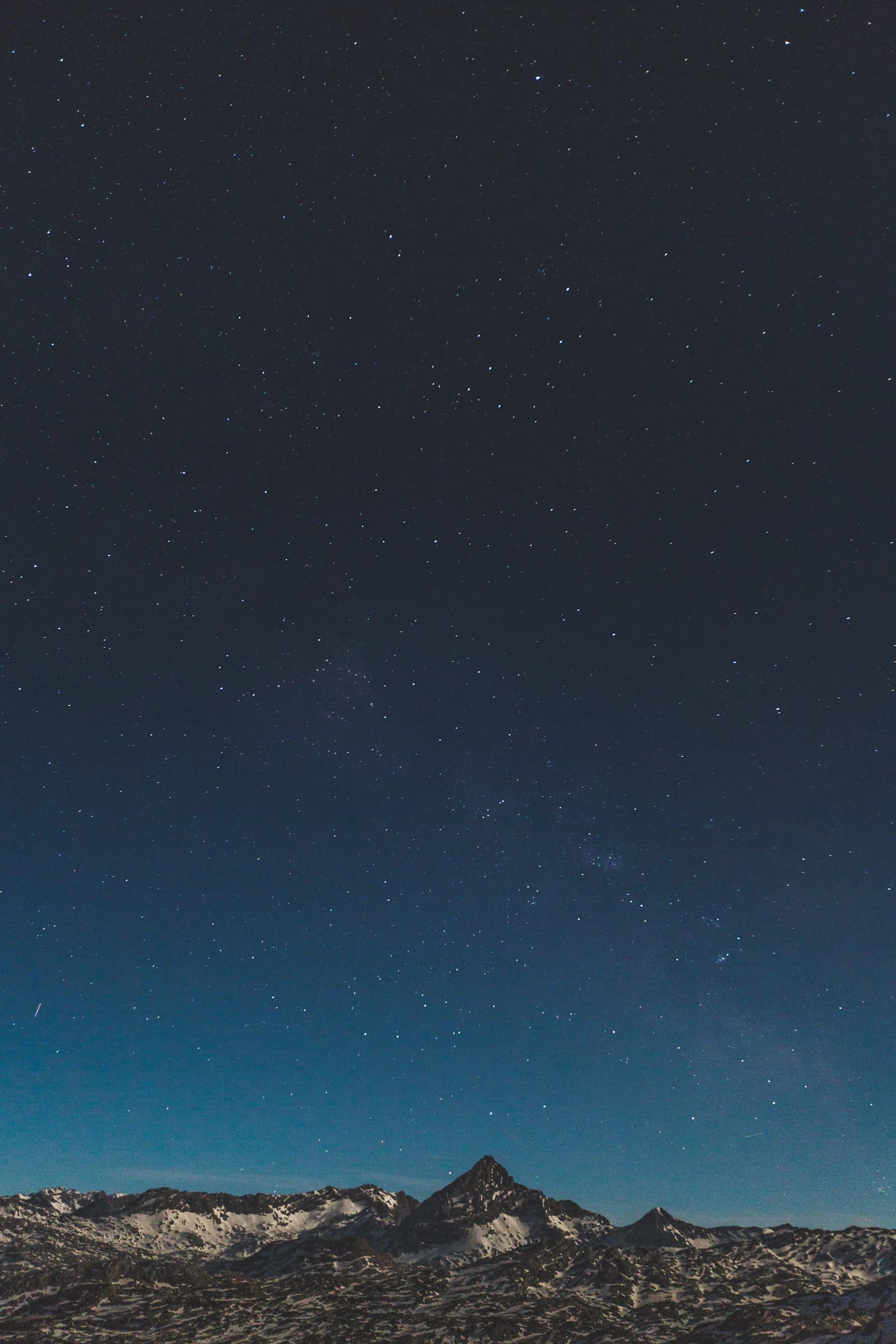 A star-filled night sky over a snow-capped Himalayan peak