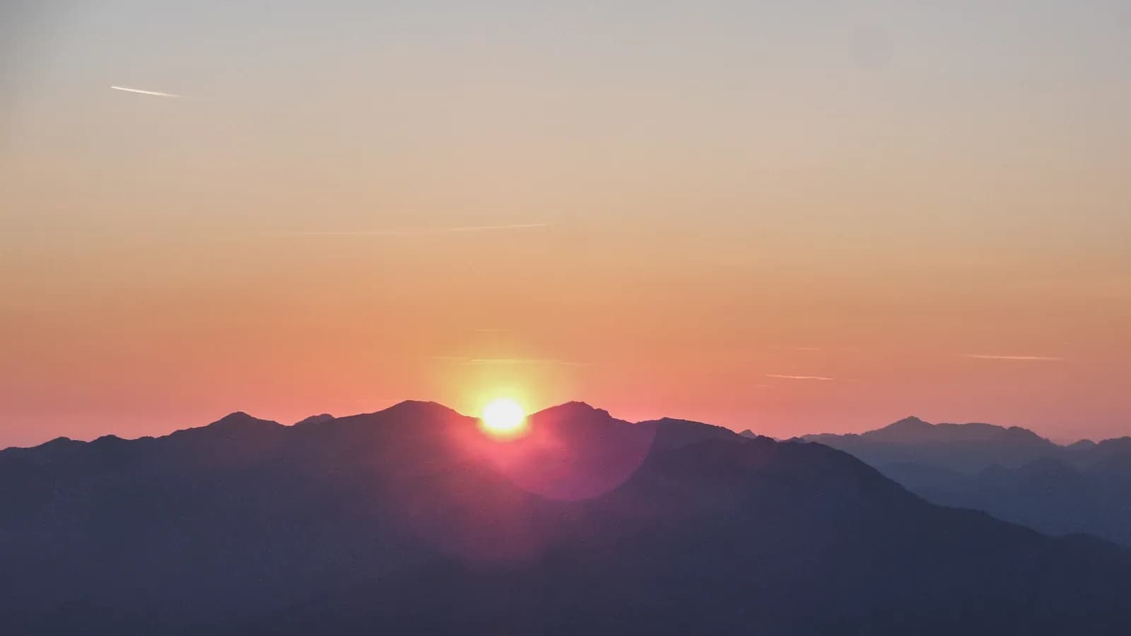 A figure in quiet meditation at sunrise in the mountains