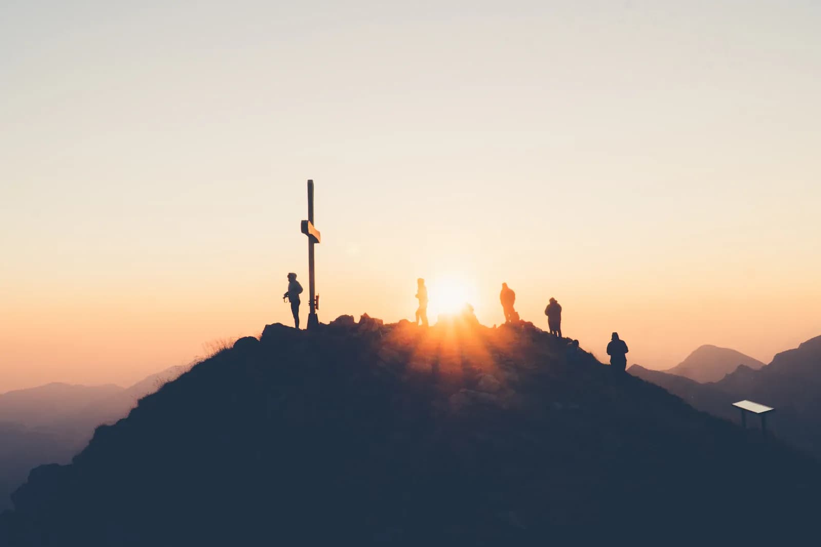 A figure in quiet meditation at sunrise in the mountains