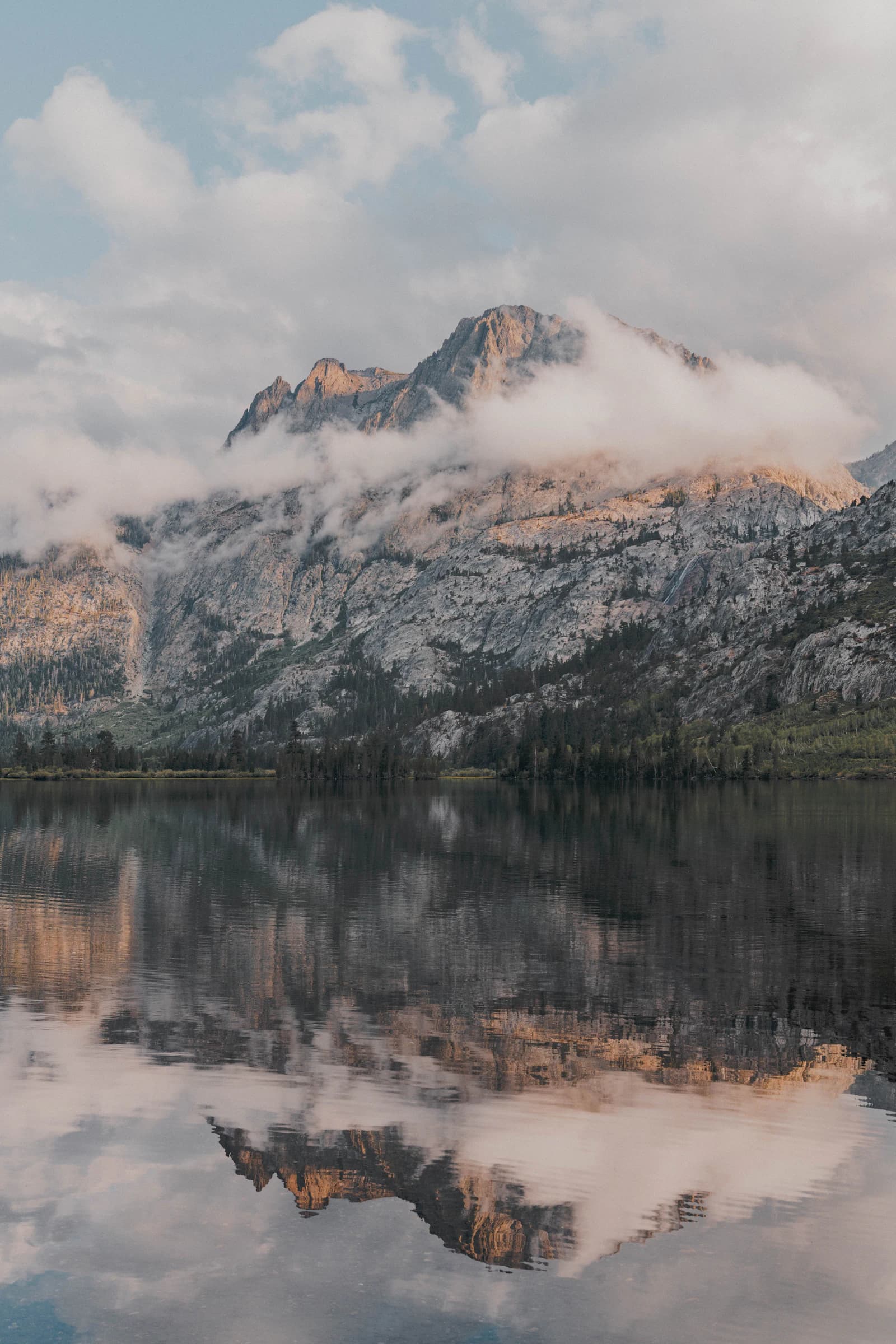 A mountain range mirrored in the still water of a lake