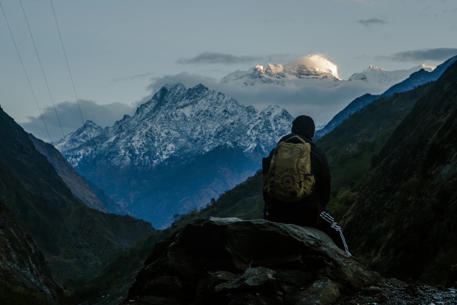 A figure sitting in quiet reflection facing the Himalayas