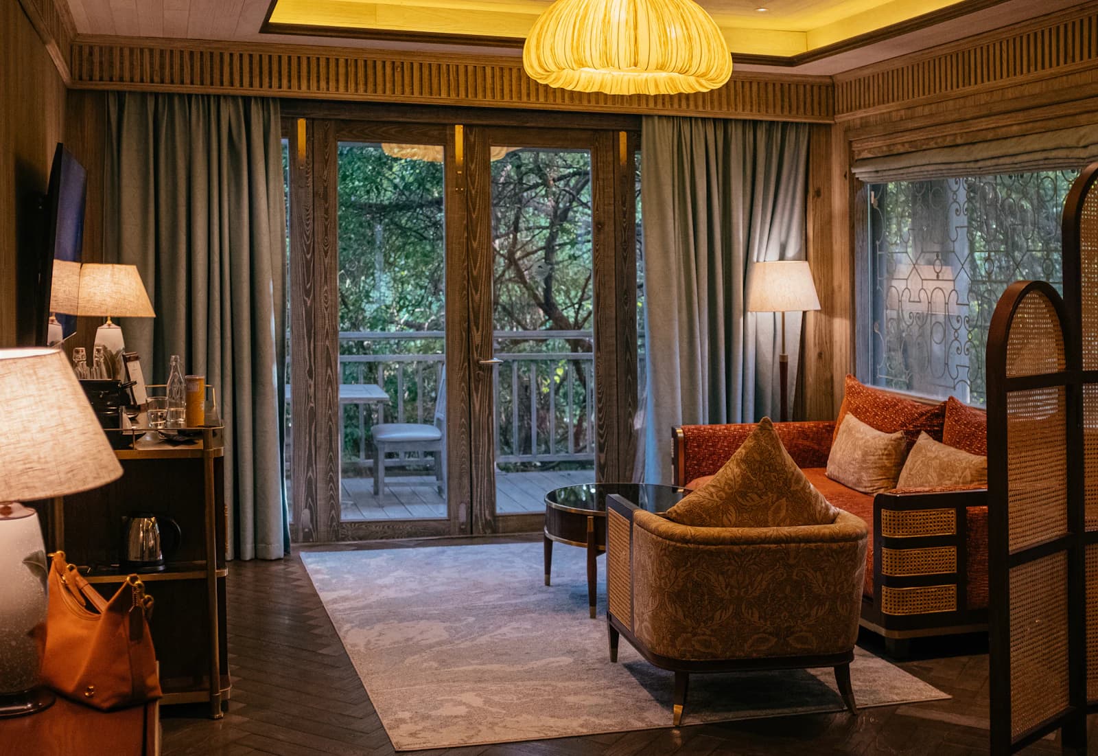 A warm, wood-paneled suite opening onto a private forest-view balcony